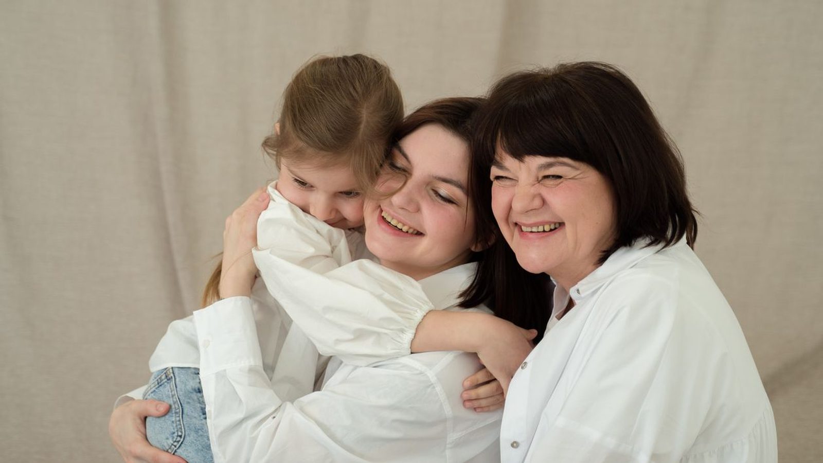 Three generations of a family embracing warmly at home