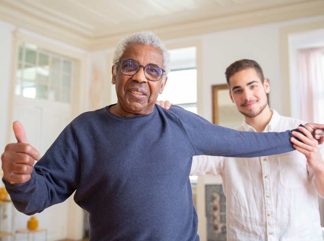 An older man giving a thumbs up during therapy